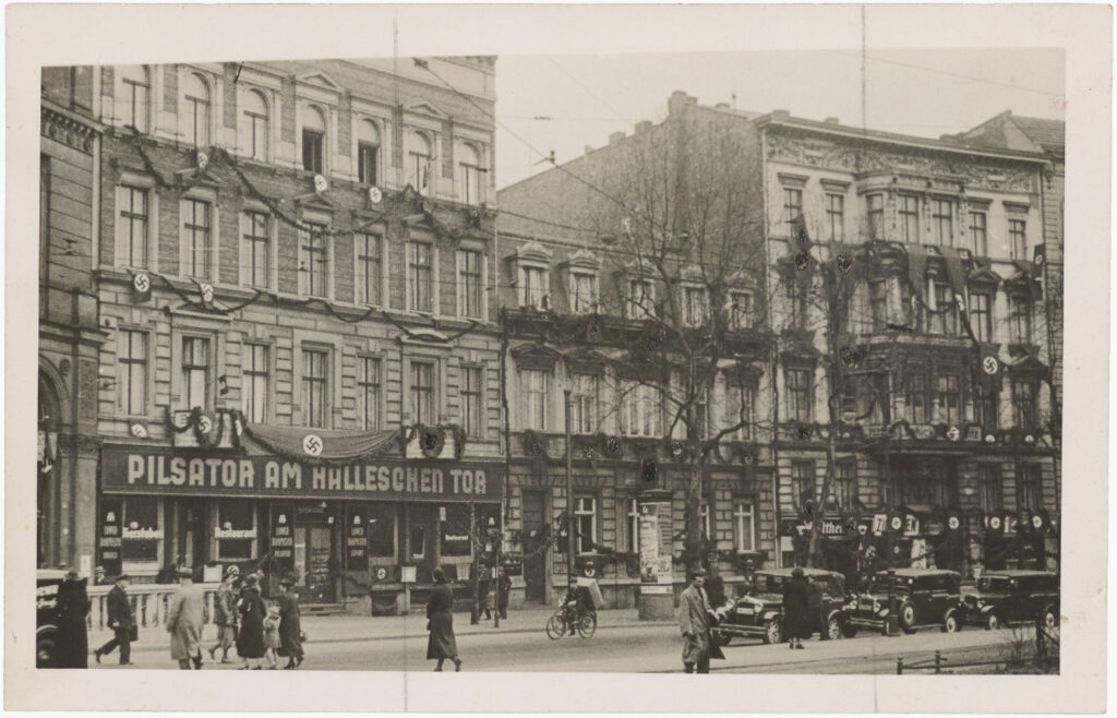 Houses 19 to 22 at Belle-Alliance-Platz (now Mehringplatz) decorated with flags and leaf garlands, undated, no publisher, Peter Plewka Collection / FHXB Friedrichshain-Kreuzberg Museum, 3121.