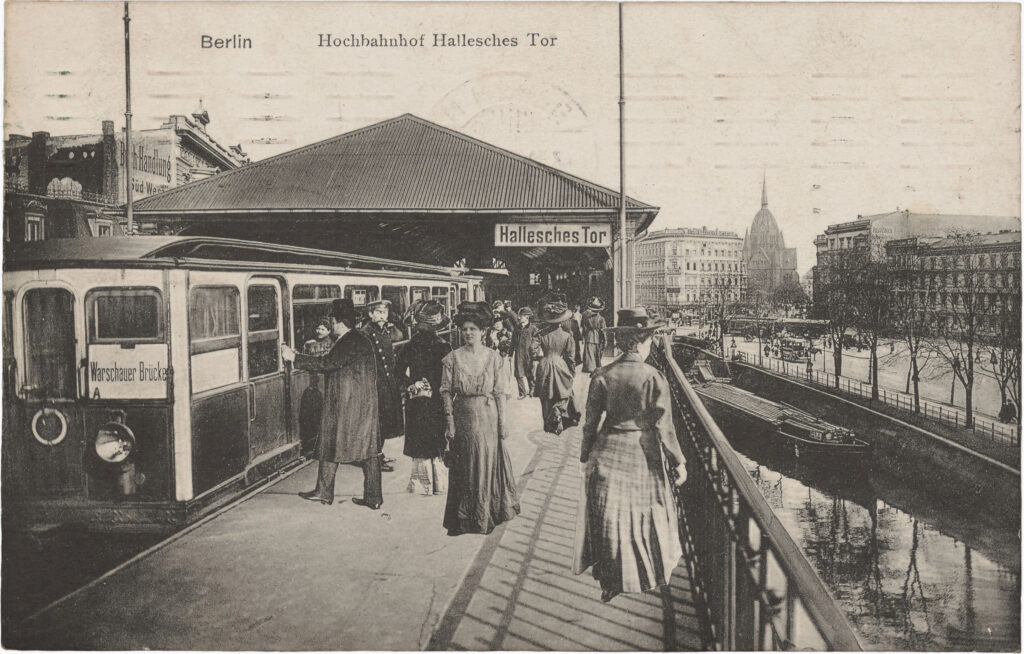 The composition of the image and the fine white borders around the depicted people and objects indicate that the motif is a montage.Hochbahnhof Hallesches Tor, no date (sent in 1910), SPP / FHXB 1643