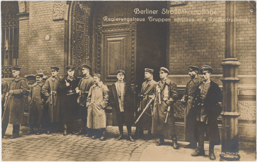Seit 1879 befand sich in der Oranienstraße die Reichsdruckerei, in der Banknoten, Pässe und Briefmarken gedruckt wurden. Sie war im November 1918 ein wichtiges Ziel der Revolutionäre. Ab 1955 wurde auch die D-Mark hier gedruckt. Nach einer Privatisierung 1994 und verschiedenen Eigentümerwechseln befindet sich das Unternehmen seit 2009 wieder im Staatsbesitz. „Berliner Straßenkampftage“, Oranienstr. 91, ca. 1919, SPP / FHXB 3650.